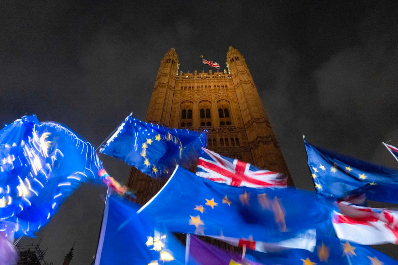 TOPSHOT - EU and Union flags flutter in the breeze as Pro and anti-Brexit demonstrators protest outside of the Houses of Parliament in central London on October 21, 2019. - UK Parliament Speaker John Bercow blocked British Prime Minister Boris Johnson from holding a vote Monday on his new Brexit divorce deal after MPs failed to back it on Saturday. "The motion will not be debated today as it would be repetitive and disorderly to do so," Bercow told lawmakers in the House of Commons. (Photo by Tolga AKMEN / AFP) (Photo by TOLGA AKMEN/AFP via Getty Images)